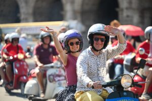 Parata di Vespa nel centro di Roma durante Vespa Roma 2026 con numerosi scooter in sfilata