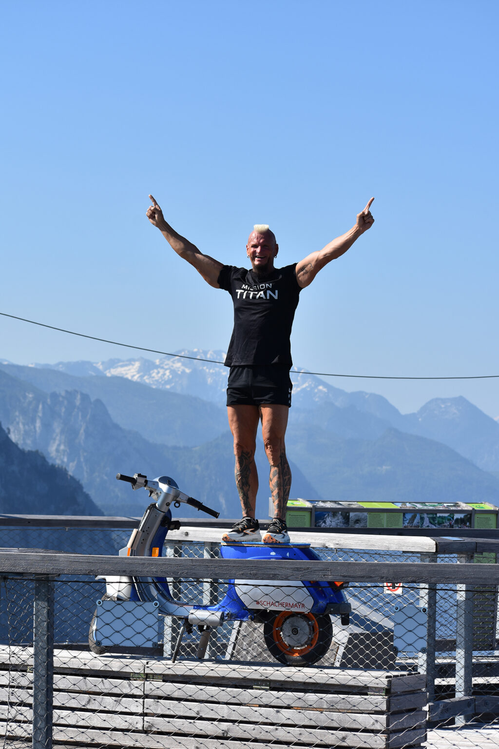 Günter Schachermayr con la Vespa PK 112 in spalla durante la salita alla torre del Salzkammergut