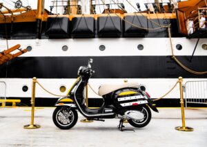 Vespa Amerigo Vespucci con livrea nera lucida, doppia banda bianca, dettagli ocra e sella in tela Olona