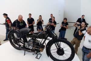 Motociclisti e visitatori nella piazza centrale della nuova casa Moto Guzzi